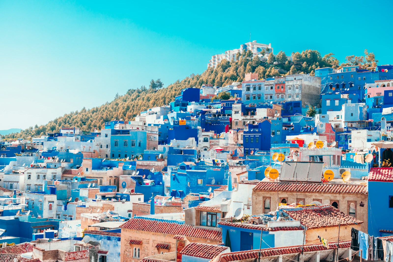 Desa Berbentuk Labirin di Maroko: Mengenal Tradisi Berber di Chefchaouen - blue and white painted houses on the cliff